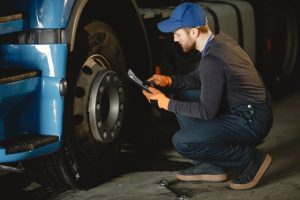 Fleet repair mechanic completing vehicle inspection to update rental management software.