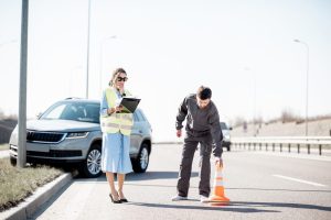 Woman and traffic enforcer working during the a car accident.