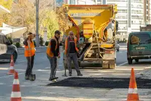 Fleet and road work crew coordinating vehicle and pedestrian safety during active construction.
