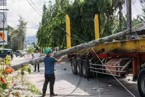 A flatbed truck involved in an accident with a downed utility pole and tangled power lines, illustrating the high cost of reactive fleet safety.
