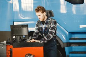 Service technician analyzing fleet vehicle diagnostic data for accident management.