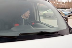 Delivery driver observing surroundings to manage micro-risks and curbside safety.