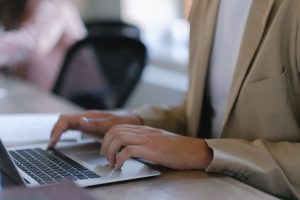 Risk manager accessing real-time fleet claims reporting and VISIBILITY portal on a laptop.